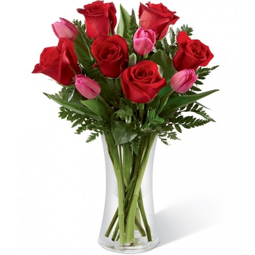 Brilliant red roses brought together with fuchsia tulips & lush greens in a classic clear glass vase to create rich in romance & sweet sentiments.